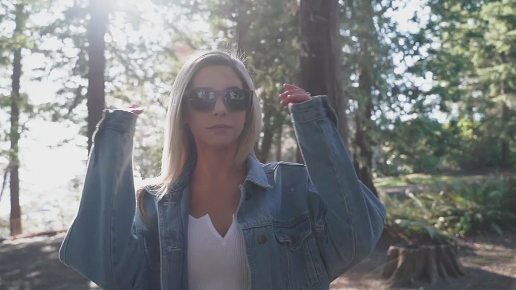 Woman in a sunny forest wearing Wildwood sunglasses