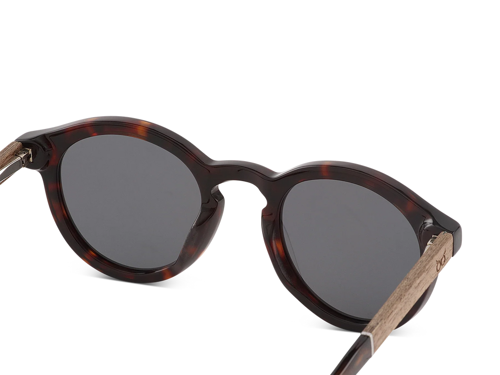 Sunglasses with tortoiseshell frame and dark lenses on a white background